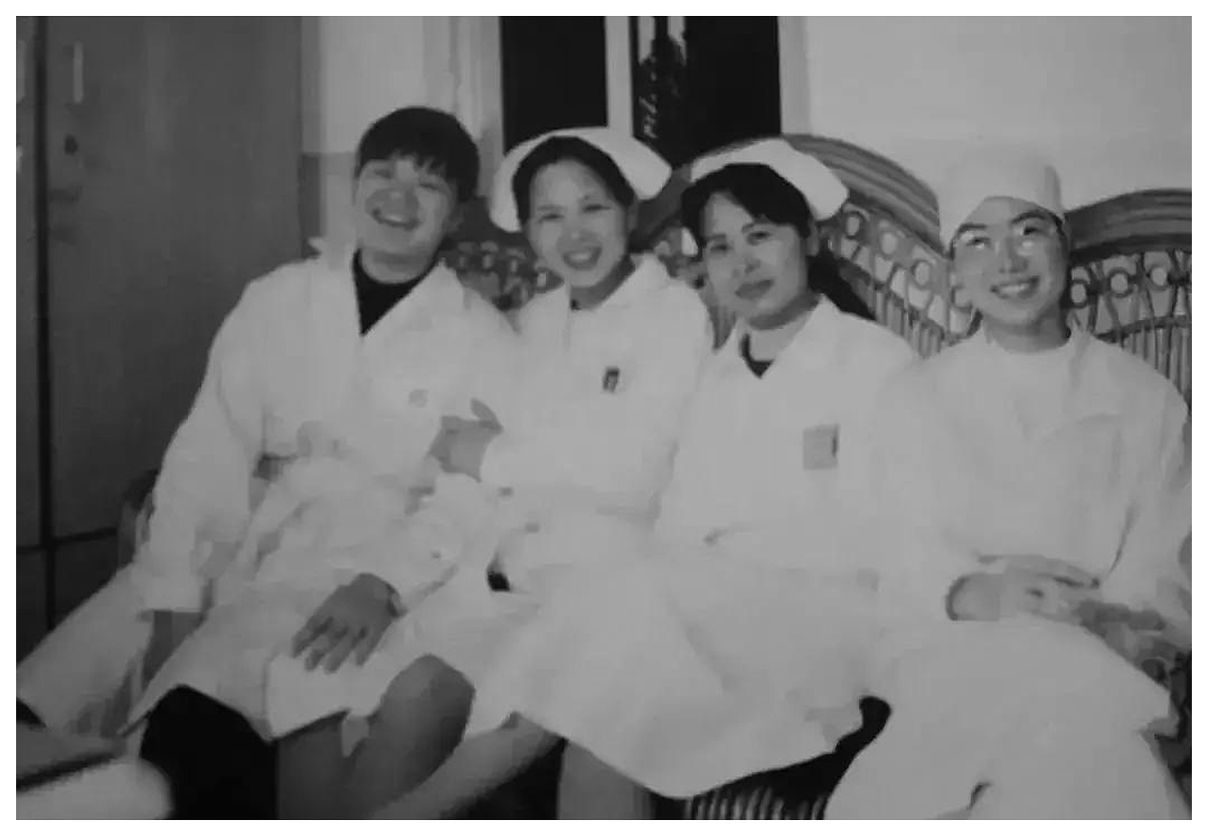 Black-and-white archival photo of nurses sitting together in uniform.